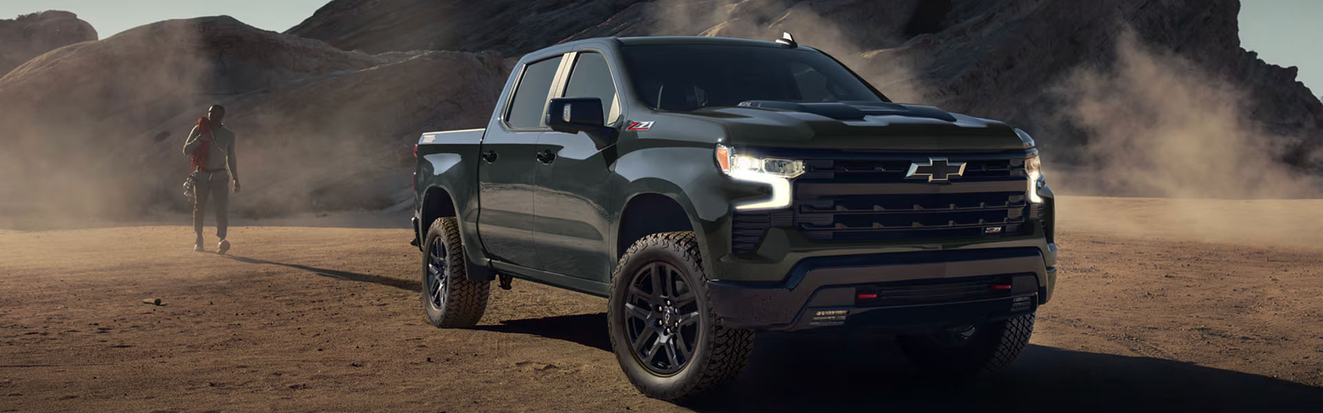 2026 Chevrolet Silverado green with black roof and alloy wheels, parked outdoors highlighting bold grille and LED headlights.