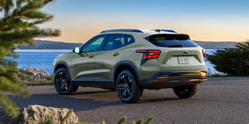 2026 Chevrolet Trax compact SUV parked by a coastal road in Miami, FL, featuring a modern design with scenic water and sunset views in the background.